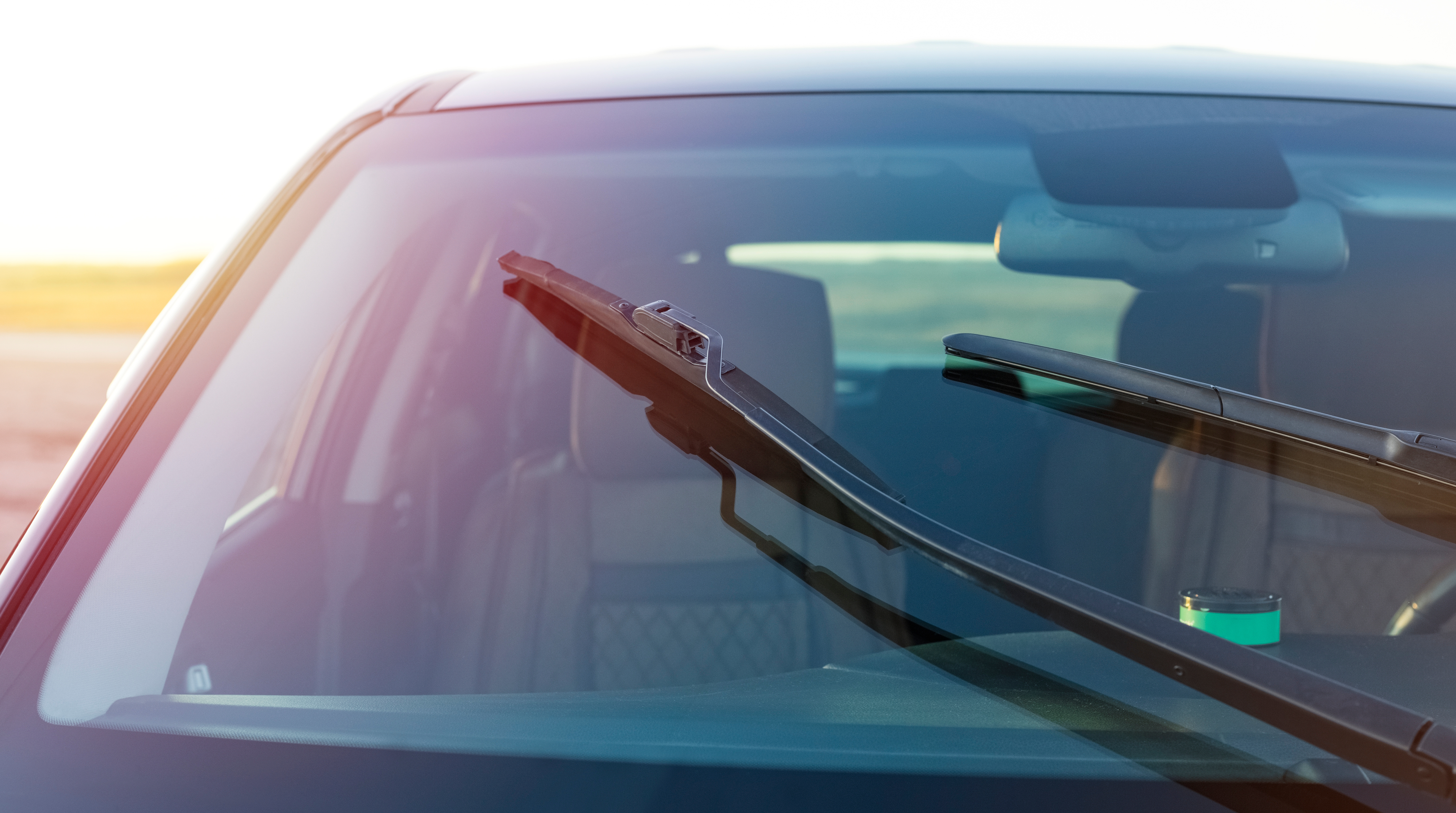 Imagem mostra detalhes de limpadores de para-brisa de um carro escuro